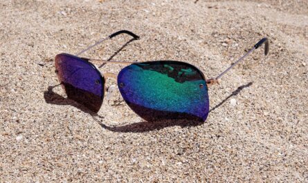 Lunettes de soleil posées sur le sable de la plage