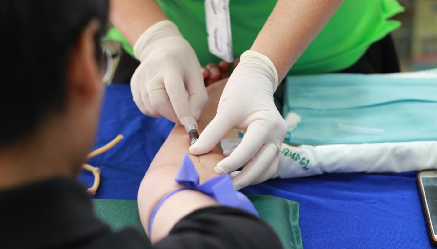 A healthcare professional administering an injection to a patient's arm during a medical procedure.