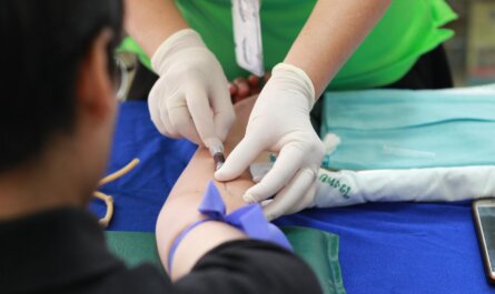 A healthcare professional administering an injection to a patient's arm during a medical procedure.