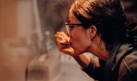 Woman cooking and tasting a dish on the stove, showcasing home culinary expertise.