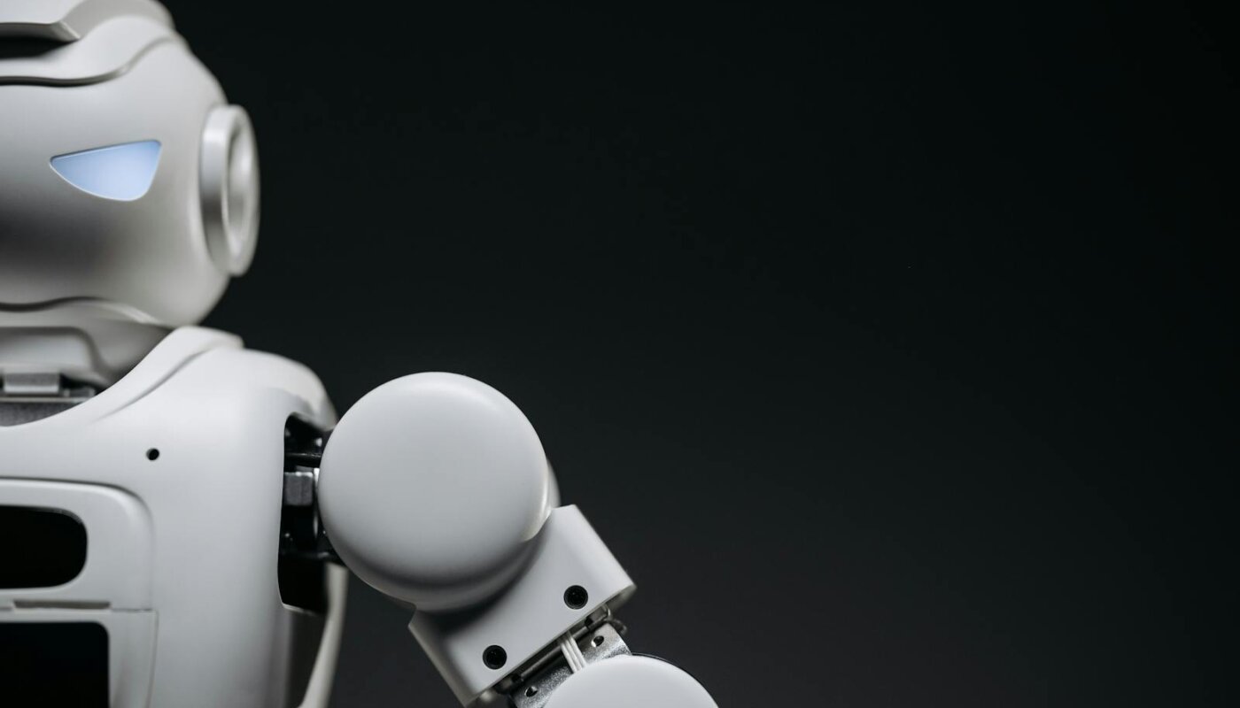 Close-up of a modern, monochrome robot arm against a dark background. Futuristic technology concept.